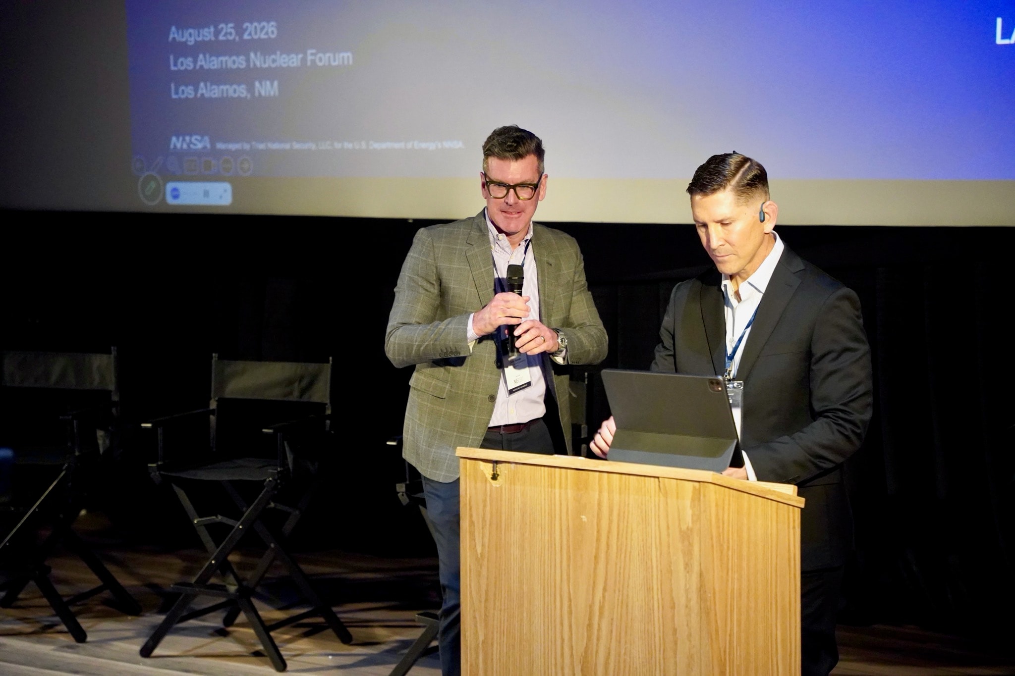 Two presenters speaking at a podium during the Los Alamos Nuclear Forum